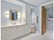 Bright bathroom featuring single vanity, framed mirror, bronze fixtures and patterned floor tiles at 2141 Gulf Of Mexico Dr Unit # 4, Longboat Key, FL 34228