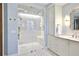 Elegant bathroom with glass shower, patterned tile walls, and bronze fixtures at 2141 Gulf Of Mexico Dr Unit # 4, Longboat Key, FL 34228
