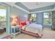 Bedroom with a plush bed, tray ceilings, and access to an outdoor balcony offering views of the palm trees at 2141 Gulf Of Mexico Dr Unit # 4, Longboat Key, FL 34228