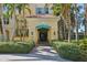 Elegant building entrance with lush landscaping, brick pathway and palm tree surroundings at 2141 Gulf Of Mexico Dr Unit # 4, Longboat Key, FL 34228