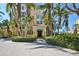 Elegant building entrance with lush landscaping, brick pathway and palm tree surroundings at 2141 Gulf Of Mexico Dr Unit # 4, Longboat Key, FL 34228