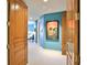 Bright hallway with artwork, hardwood doors, and leading to a bedroom with colorful accents at 2141 Gulf Of Mexico Dr Unit # 4, Longboat Key, FL 34228