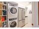 Modern laundry room featuring front-loading washer/dryer and built-in shelving for organization at 2141 Gulf Of Mexico Dr Unit # 4, Longboat Key, FL 34228