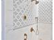 Close up of elegant shower with patterned tile walls, bronze fixtures and controls at 2141 Gulf Of Mexico Dr Unit # 4, Longboat Key, FL 34228