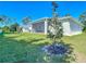Well-maintained backyard with green grass, landscaping, and a screened patio at 2186 Yalta Ter, North Port, FL 34286