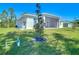 Backyard featuring a newly planted tree and a view of the screened porch at 2186 Yalta Ter, North Port, FL 34286