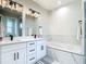 Modern bathroom featuring dual sinks, white cabinetry and marble surround tub at 2186 Yalta Ter, North Port, FL 34286