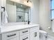 Modern bathroom featuring a white vanity with black hardware, a large mirror, and a toilet with a minimalist design at 2186 Yalta Ter, North Port, FL 34286