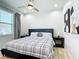 Well-lit bedroom with a black headboard, stylish bedding, modern art, a ceiling fan, and a window providing natural light at 2186 Yalta Ter, North Port, FL 34286