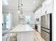 Bright kitchen features a large island, stainless steel appliances, white cabinetry, and pendant lighting at 2186 Yalta Ter, North Port, FL 34286