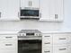 This bright kitchen features white subway tile backsplash, stainless appliances, and white cabinetry with dark hardware at 2186 Yalta Ter, North Port, FL 34286