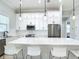 Bright, eat-in kitchen features white cabinetry, stainless steel appliances, a large quartz island, and pendant lights at 2186 Yalta Ter, North Port, FL 34286