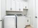 Functional laundry room with front load machines, upper cabinets, and a sink at 2186 Yalta Ter, North Port, FL 34286