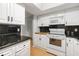 Well-lit kitchen with white cabinets, granite countertops and stainless steel appliances at 2645 Belvoir Blvd, Sarasota, FL 34237