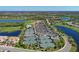 Aerial view of the community featuring a golf course, lakes, clubhouse, community pool, and tennis courts at 322 Winding Brook Ln # 103, Bradenton, FL 34212