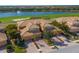 Stunning aerial view of home with barrel tile roof, lush landscaping, water view, and golf course at 322 Winding Brook Ln # 103, Bradenton, FL 34212