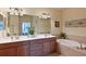 Bathroom featuring double sinks, vanity, large mirror, and soaking tub at 322 Winding Brook Ln # 103, Bradenton, FL 34212