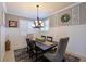 Dining room with modern chandelier, plantation shutters, wainscoting, and elegant decor at 322 Winding Brook Ln # 103, Bradenton, FL 34212