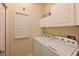 Laundry room with stacked washer and dryer and white cabinets at 322 Winding Brook Ln # 103, Bradenton, FL 34212