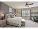 Comfortable primary bedroom includes neutral decor, a ceiling fan, and a window with plantation shutters at 322 Winding Brook Ln # 103, Bradenton, FL 34212