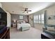 Spacious main bedroom featuring a ceiling fan, a sitting area, and plantation shutters at 322 Winding Brook Ln # 103, Bradenton, FL 34212
