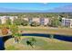 An aerial view shows condo buildings overlooking a golf course with a pond and trees at 3620 Ironwood Cir # 406O, Bradenton, FL 34209