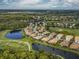Stunning aerial view of the golf course community with winding waterways and mature trees at 375 Fairway Isles Ln, Bradenton, FL 34212