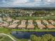 Expansive aerial view of a golf community featuring homes, lush greenery, and serene water features at 375 Fairway Isles Ln, Bradenton, FL 34212