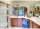 Well-lit bathroom featuring tile floors, double sinks, shower with glass door, and neutral color scheme at 375 Fairway Isles Ln, Bradenton, FL 34212