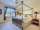 Bright bedroom featuring a four-poster bed, carpet floors, ceiling fan and a large window at 375 Fairway Isles Ln, Bradenton, FL 34212