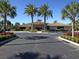 Beautifully landscaped clubhouse exterior featuring palm trees, colorful flowerbeds, and ample parking at 375 Fairway Isles Ln, Bradenton, FL 34212