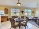 Dining area with wicker chairs, glass table, and a view into a bright sunroom at 375 Fairway Isles Ln, Bradenton, FL 34212