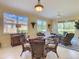 Bright dining area with a glass-topped table, wicker chairs, and views of the outdoor landscape at 375 Fairway Isles Ln, Bradenton, FL 34212