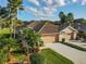 Aerial view of a well-maintained single-story home with tile roof, lush landscaping, and a spacious driveway at 375 Fairway Isles Ln, Bradenton, FL 34212