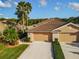 Overhead view of a single-story home featuring a tile roof, lush landscaping, and a spacious two-car garage at 375 Fairway Isles Ln, Bradenton, FL 34212