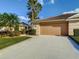 Beautiful home featuring well-maintained landscaping, mature palm trees, and a spacious two-car garage at 375 Fairway Isles Ln, Bradenton, FL 34212