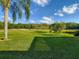 Scenic golf course view with lush green fairways, sand traps, and mature trees under a partly cloudy blue sky at 375 Fairway Isles Ln, Bradenton, FL 34212