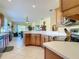 Open kitchen with warm wood cabinetry, white countertops, and seamless connection to the adjacent dining area at 375 Fairway Isles Ln, Bradenton, FL 34212