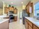 Well-lit kitchen with stainless steel appliances, wood cabinets, and white countertops at 375 Fairway Isles Ln, Bradenton, FL 34212