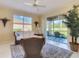 Bright lanai features wicker furniture, tropical plants and a view of the serene outdoor space at 375 Fairway Isles Ln, Bradenton, FL 34212