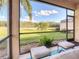 View from the screened lanai overlooking a grassy backyard at 375 Fairway Isles Ln, Bradenton, FL 34212