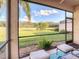 View from the screened lanai overlooking a grassy backyard with lake at 375 Fairway Isles Ln, Bradenton, FL 34212