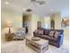 Comfortable living room with a sofa, patterned armchairs, and a view of the adjacent kitchen and dining area at 375 Fairway Isles Ln, Bradenton, FL 34212