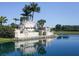 Elegant 'Heritage Harbour' community sign reflected in a tranquil lake, surrounded by palm trees at 375 Fairway Isles Ln, Bradenton, FL 34212