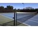 Outdoor tennis court featuring a blue playing surface, black net and fenced perimeter at 375 Fairway Isles Ln, Bradenton, FL 34212