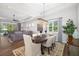 Open-concept dining area with a chandelier, hardwood floors, and seamless flow into the living room at 438 Whistler Gln, Bradenton, FL 34212