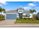 Charming single-Gathering home boasting a well-maintained lawn, lush landscaping, and a striking blue garage door at 438 Whistler Gln, Bradenton, FL 34212