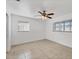 Well-lit bedroom with neutral tile, white walls, and a ceiling fan at 4608 Park Acres Dr, Bradenton, FL 34207