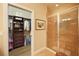 Bathroom featuring a walk-in shower with glass doors and an adjacent walk-in closet at 5020 Savona Run, Bradenton, FL 34211