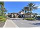 Elegant community entrance featuring lush landscaping, towering palms, and a stately building, creating a welcoming ambiance at 5020 Savona Run, Bradenton, FL 34211